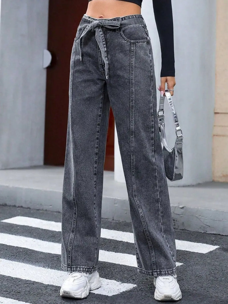 Person wearing high-waisted black jeans with a blurred background
