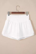 White shorts on a hanger against a beige background