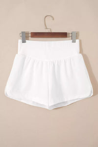 White shorts on a hanger against a beige background