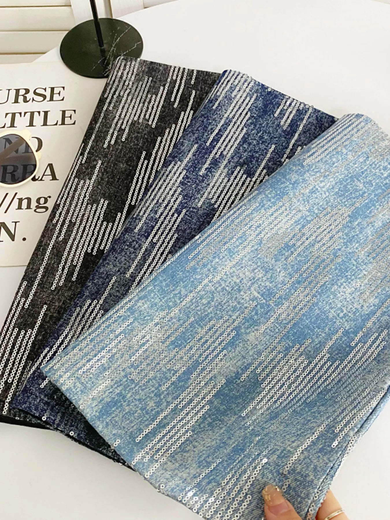 Two textured fabric samples, one black and white patterned and one blue and white patterned, on a white surface.