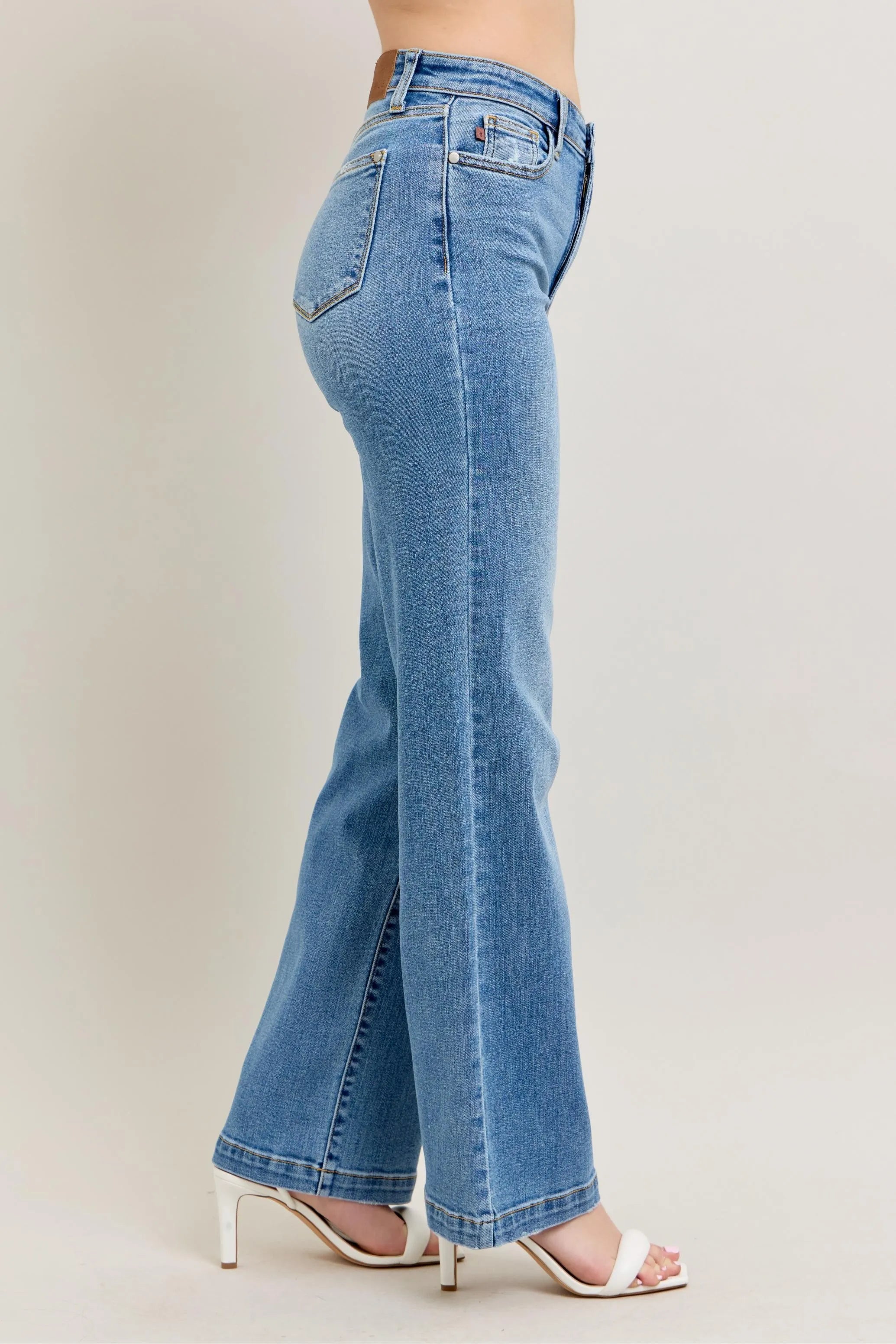 Light blue flared jeans worn by a person on a plain background
