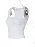White sleeveless top with pearl embellishments on a white background