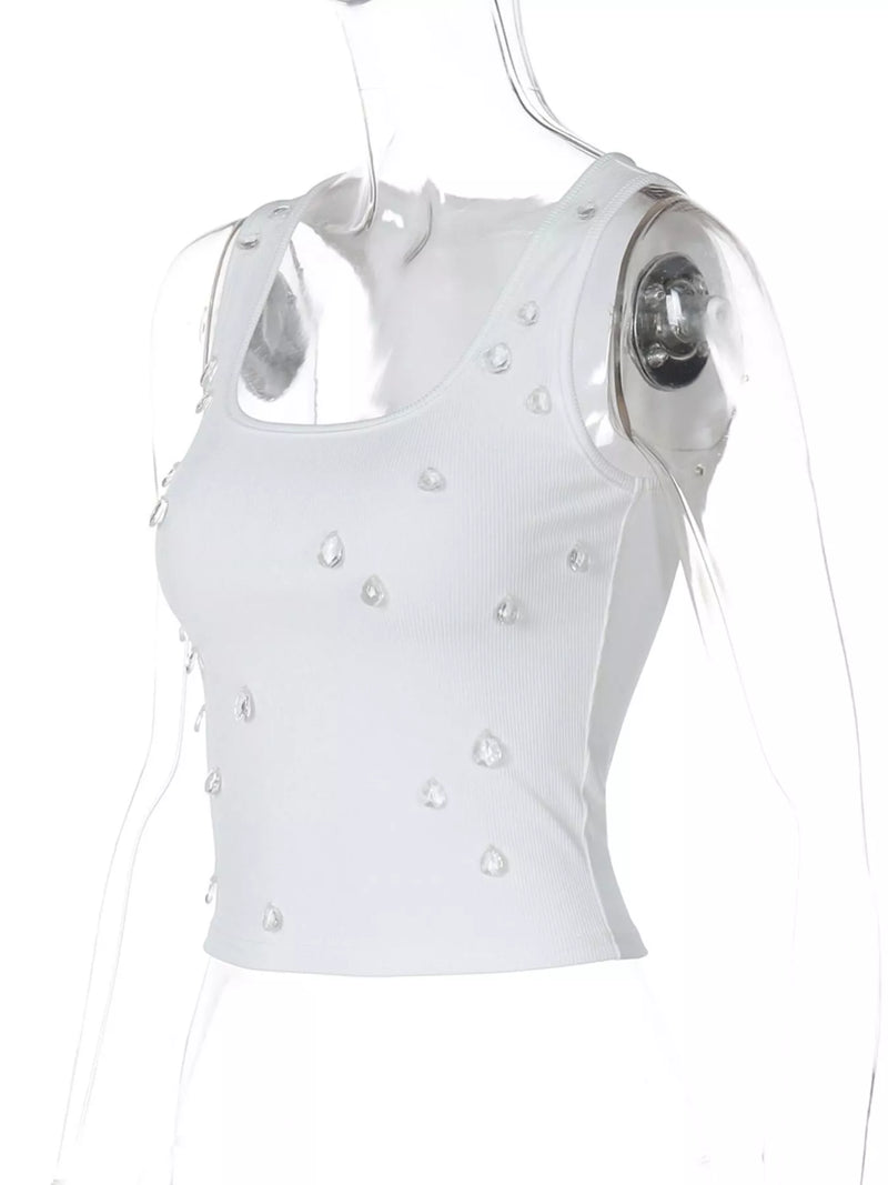 White sleeveless top with pearl embellishments on a white background