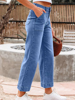 Person wearing blue wide-leg jeans with a blurred background