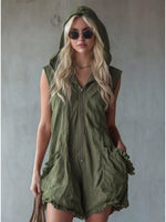 Woman wearing a green hooded romper against a plain background