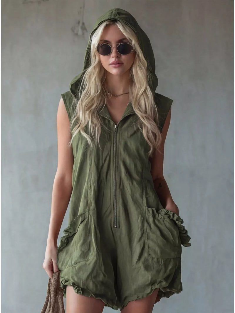 Woman wearing a green hooded romper against a plain background