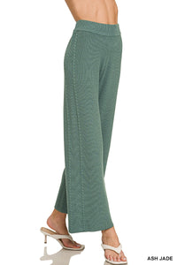 Green pants being worn on a white background