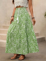 Person wearing a green and white patterned skirt with a beige background