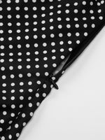 Black fabric with white polka dots on a white background