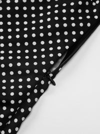 Black fabric with white polka dots on a white background