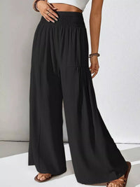 Black wide-leg pants worn by a person on a white background