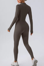 Person wearing a brown long-sleeve jumpsuit on a light gray background