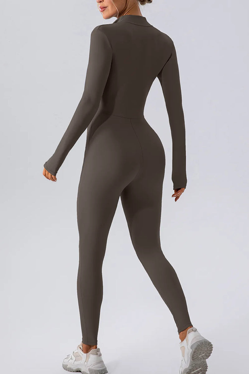 Person wearing a brown long-sleeve jumpsuit on a light gray background