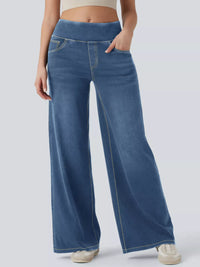 Person wearing blue wide-leg jeans on a plain background