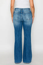 Blue jeans worn by a person on a white background