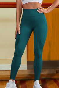 Person wearing teal leggings with a neutral background