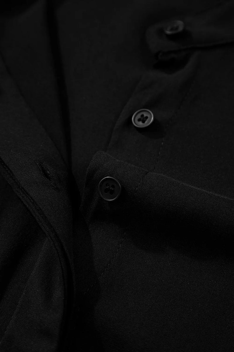 Close-up of a black coat with buttons on a dark background