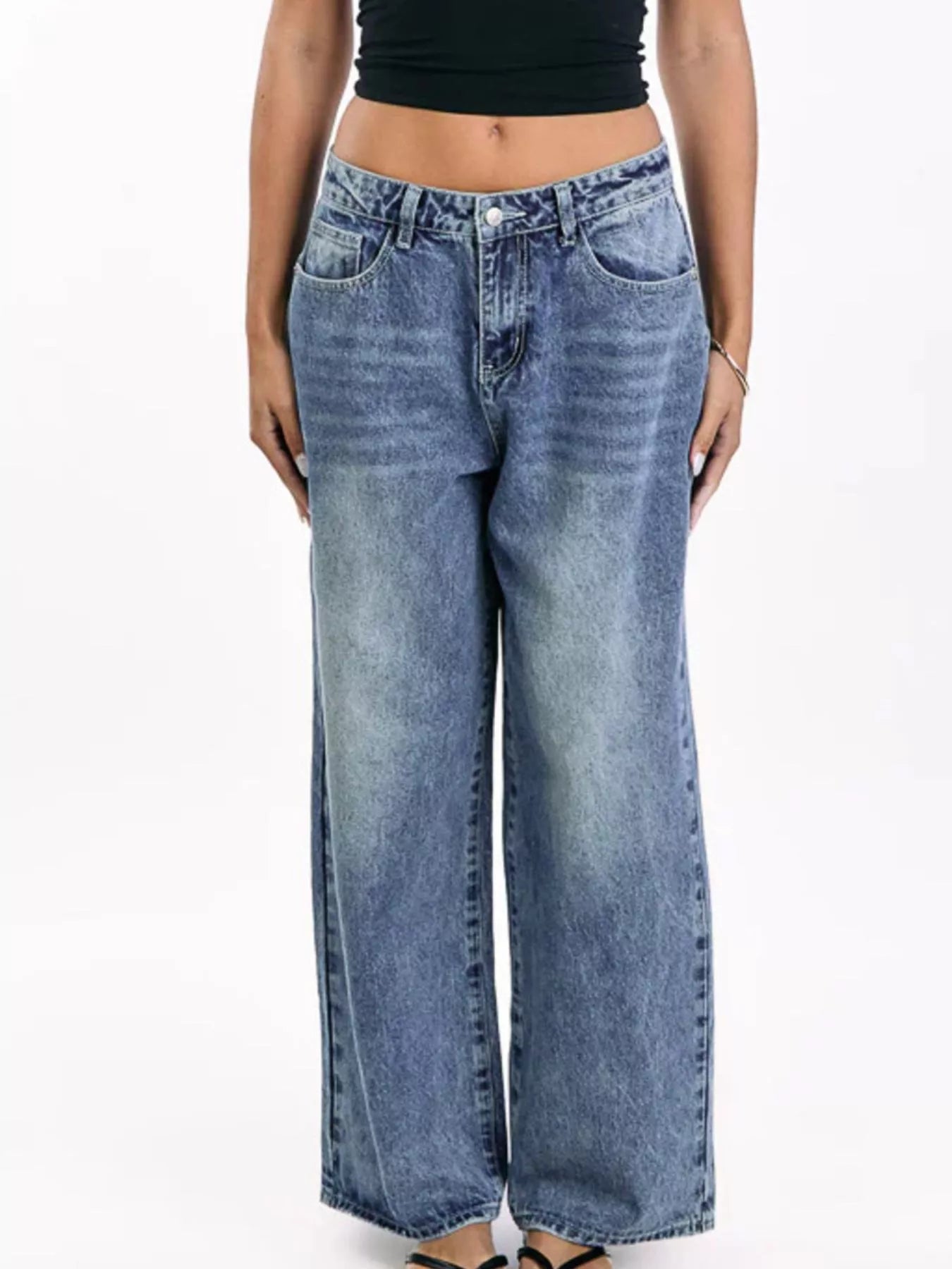 Person wearing blue wide-leg jeans on a white background