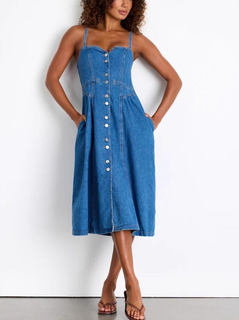Woman wearing a blue denim dress against a white background
