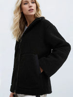 Woman wearing a black jacket against a white background