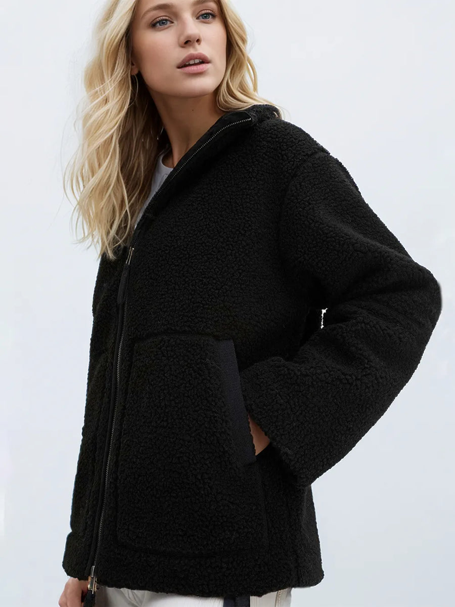 Woman wearing a black jacket against a white background