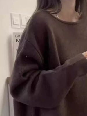 Person wearing a dark brown oversized sweater indoors.