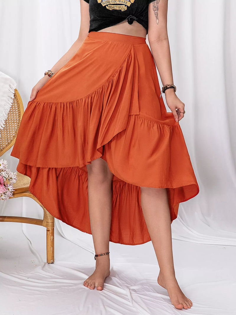 Person wearing an orange tiered skirt on a white background