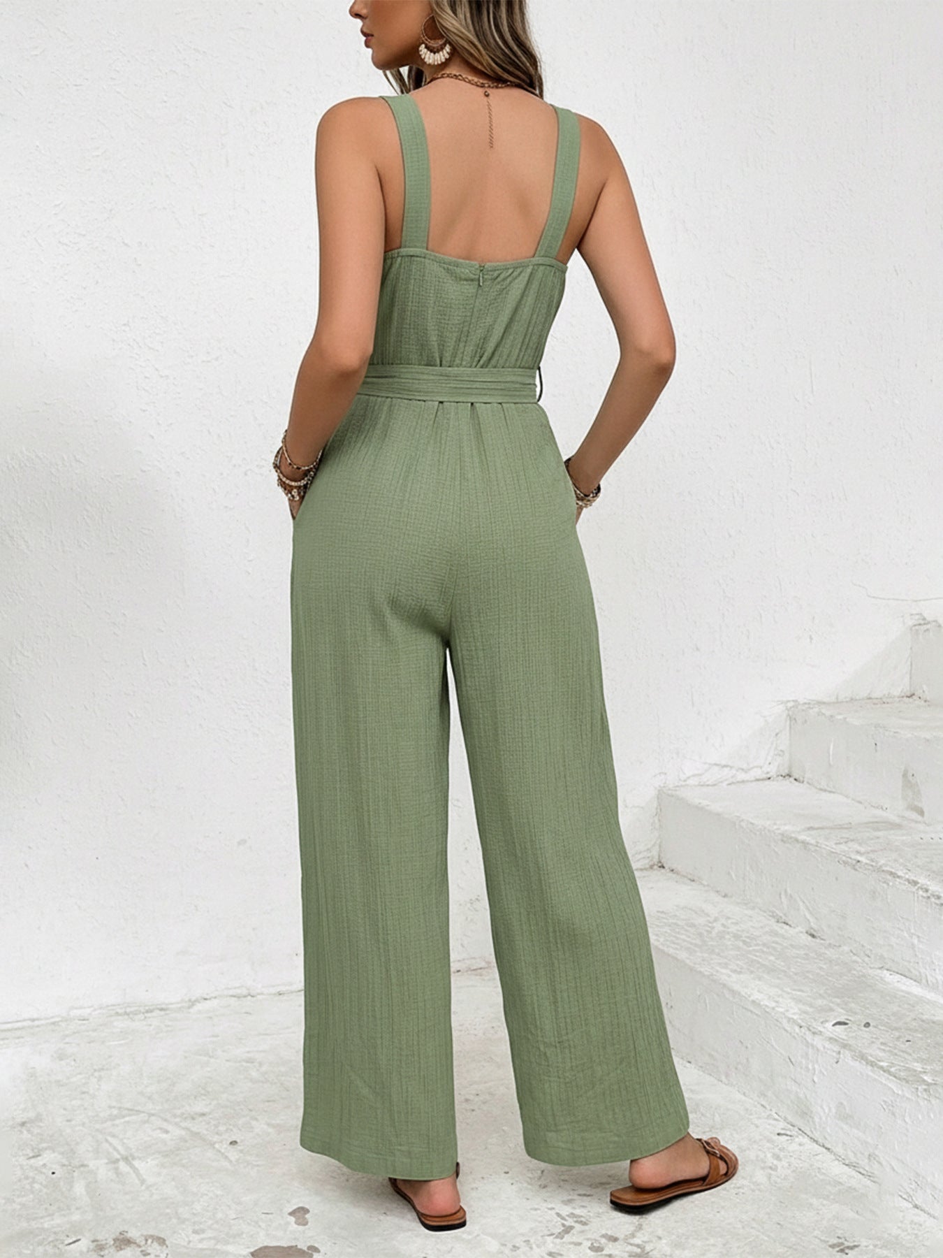 Woman wearing a green jumpsuit on a white background