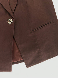 Brown blazer with a gold button on a light gray background
