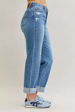 Light blue jeans worn by a person on a plain background