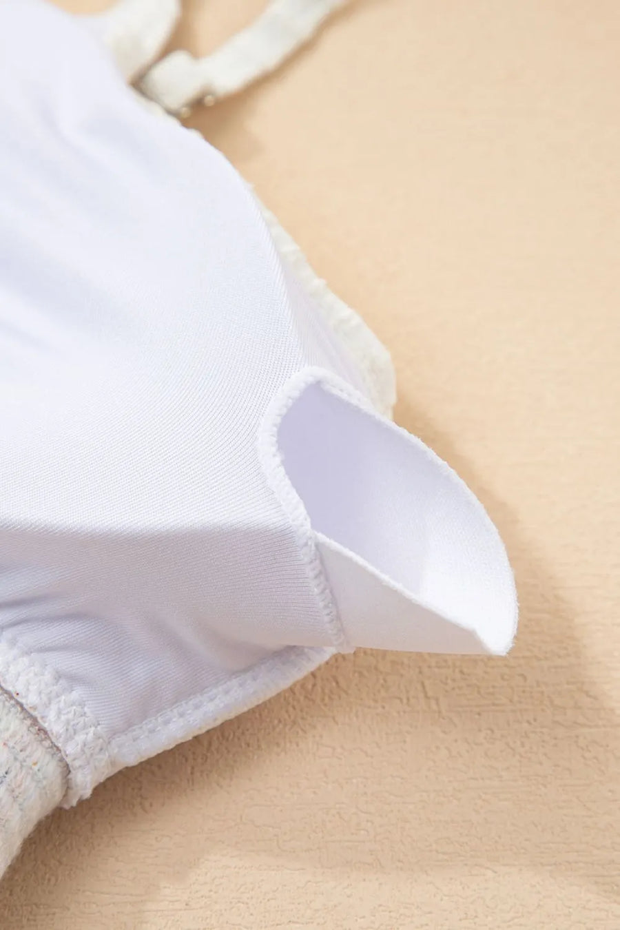 Close-up of a white shirt collar on a beige background