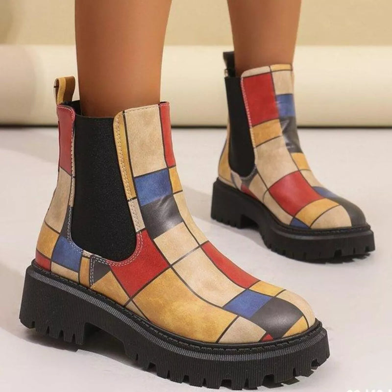 Colorful patchwork boots on a neutral background