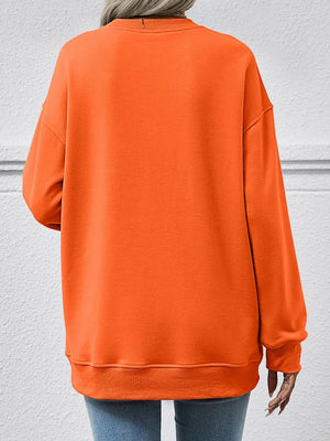 Orange sweatshirt worn by a person on a gray background