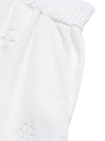 Close-up of a white textured fabric with a subtle pattern on a white background