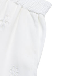 Close-up of a white textured fabric with a subtle pattern on a white background