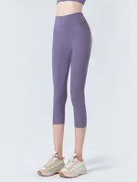 Person wearing purple leggings and white sneakers on a light gray background