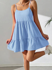 Woman wearing a light blue dress with a plain background