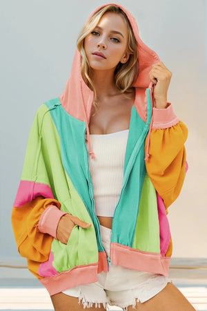 Woman wearing a colorful hoodie with a neutral background