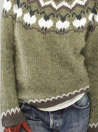 Green knitted sweater with a pattern worn by a person, focusing on the garment.
