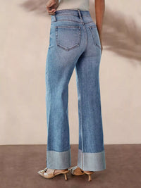 Blue jeans worn by a person on a neutral background