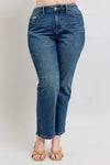 Blue jeans worn by a person on a plain background