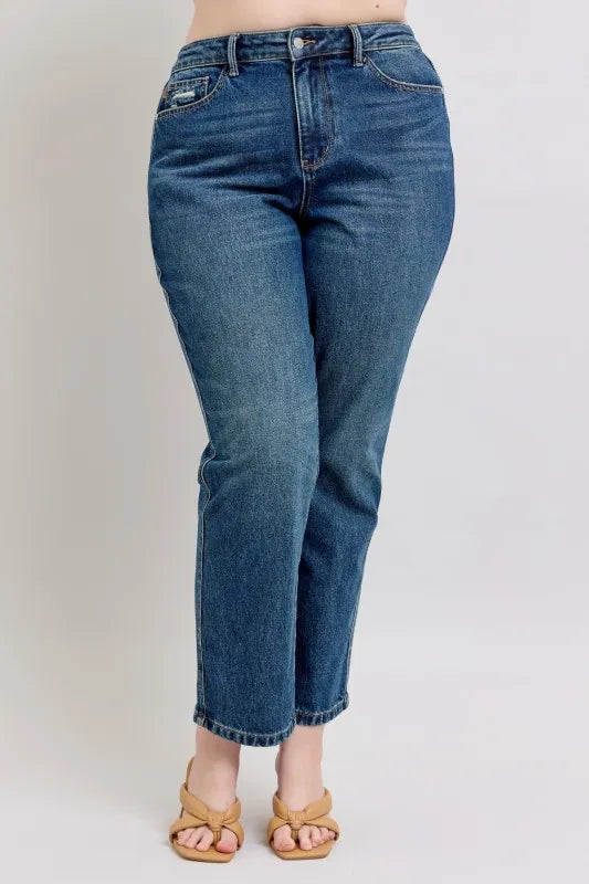 Blue jeans worn by a person on a plain background