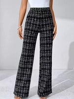 Black and white plaid pants worn by a person on a light gray background