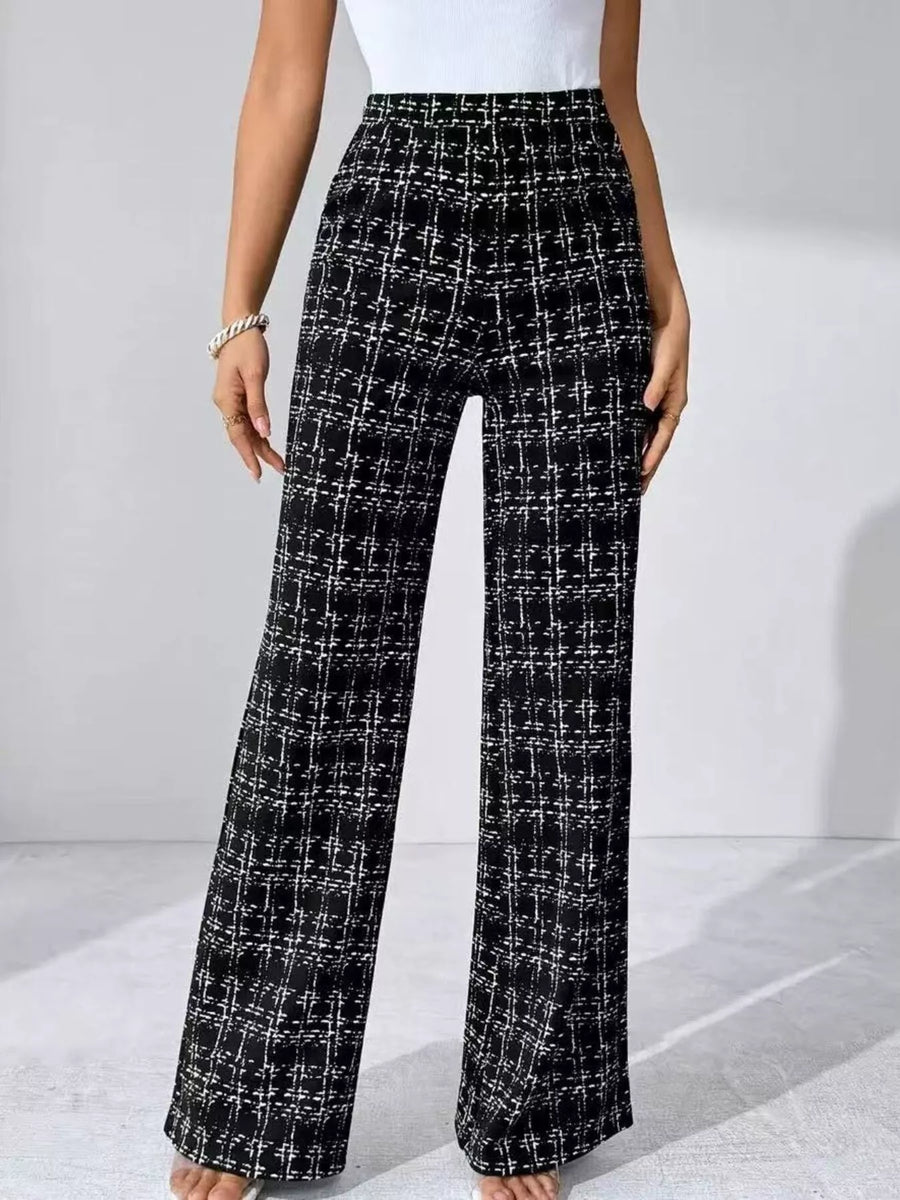 Black and white plaid pants worn by a person on a light gray background