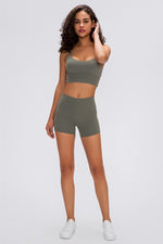 Woman wearing a green athletic outfit on a white background