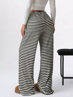 Black and white striped pants worn by a person on a white background