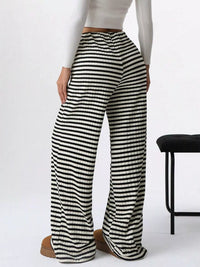 Black and white striped pants worn by a person on a white background