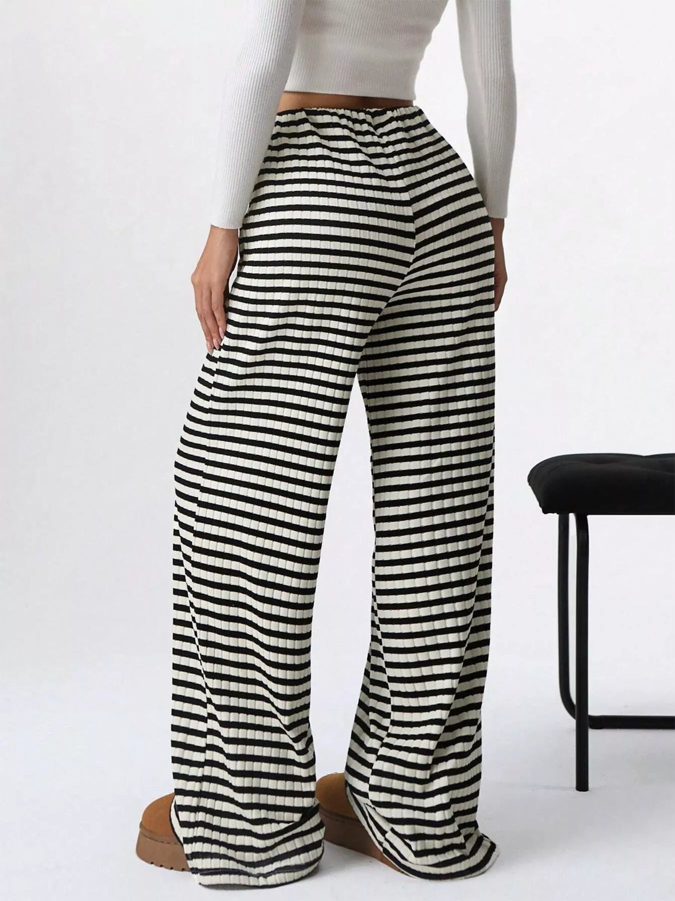 Black and white striped pants worn by a person on a white background