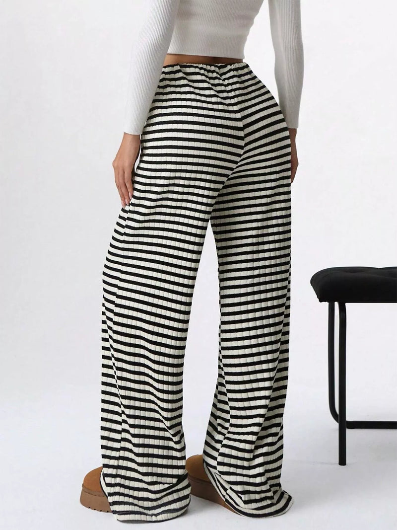 Black and white striped pants worn by a person on a white background