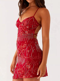 Red beaded dress worn by a model on a white background